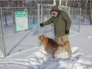 A man and his dog brave the cold as the enter the snow-covered Crosslake Dog Park.