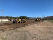 Road grader and a payloader cutting material from the project site.
