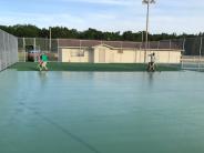 Lee Sports applying layers of green acrylic to the basketball court