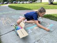 Girl drawing on the sidewalk with chalk